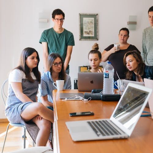 pexels-photo-1595385-1595385 Group of young professionals engaged in a collaborative meeting in a modern office setting.