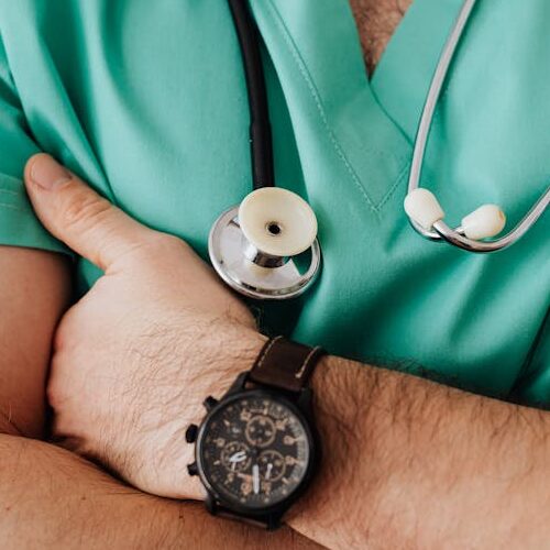 pexels-photo-4021775-4021775 Close-up of a healthcare professional with arms crossed wearing medical scrubs and stethoscope.
